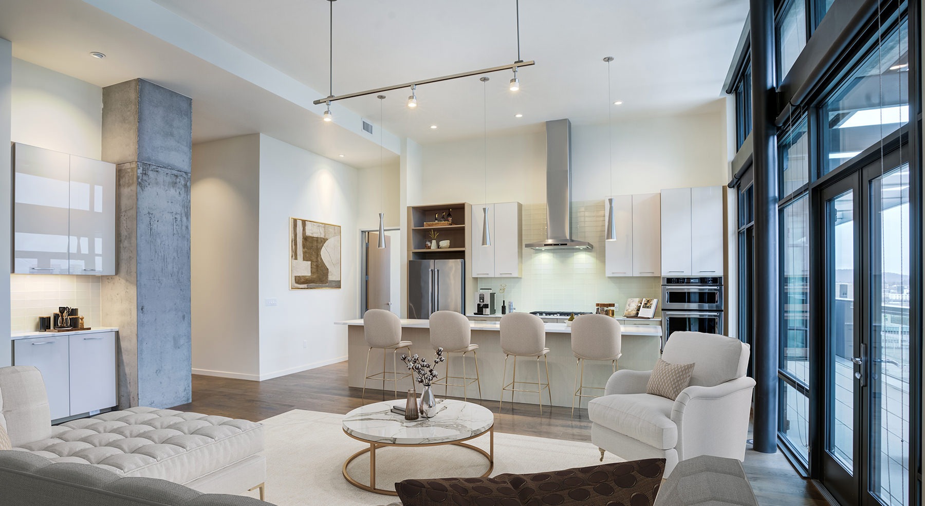 Spacious well lit living room with large floor to ceiling windows 