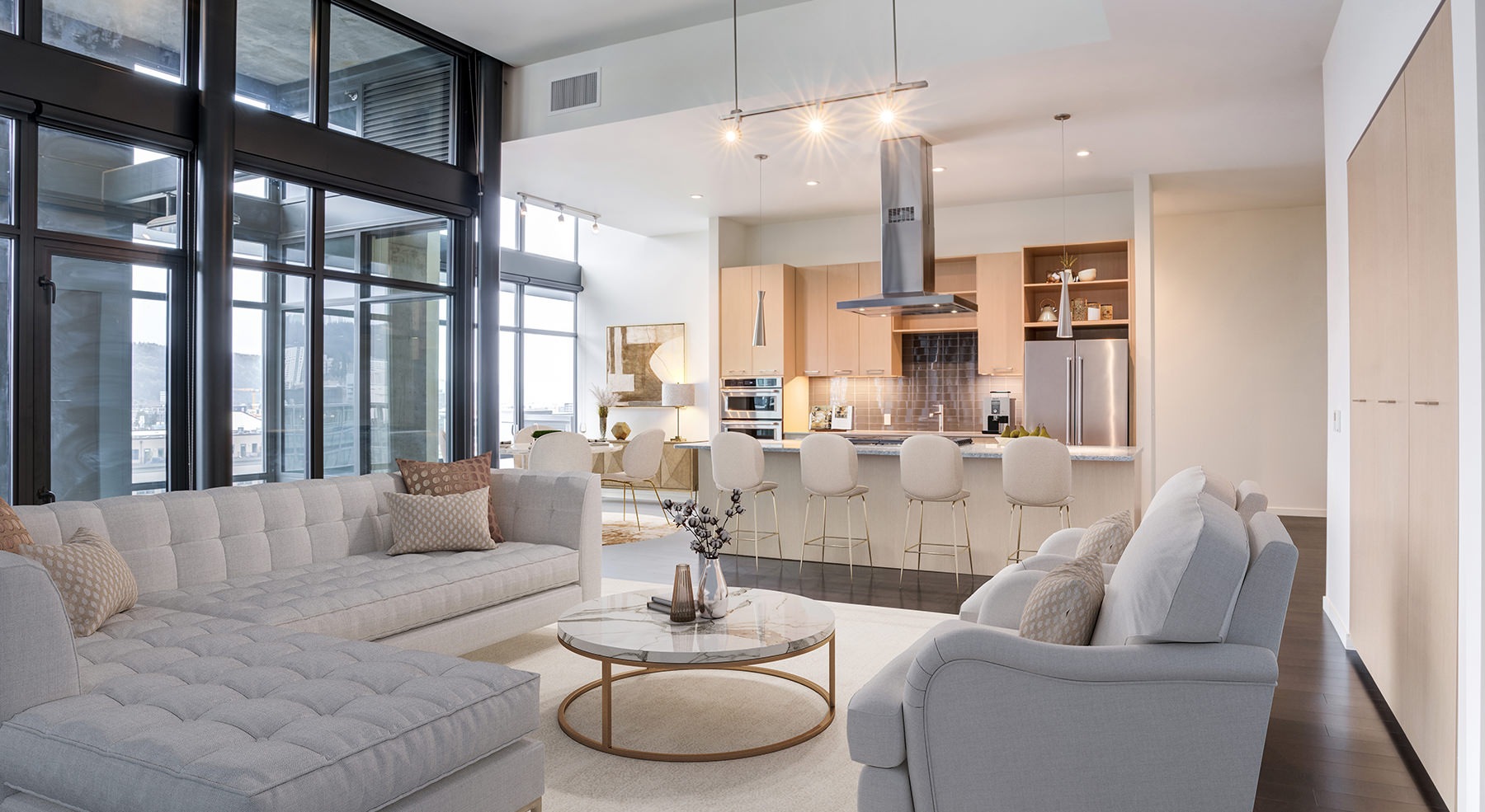 Spacious well lit living room with large floor to ceiling windows 