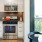 Spacious and well lit kitchen with wood floors and stainless steel appliances. 