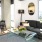 Spacious and well lit living room with wood floors and an open floor plan with access to the kitchen.